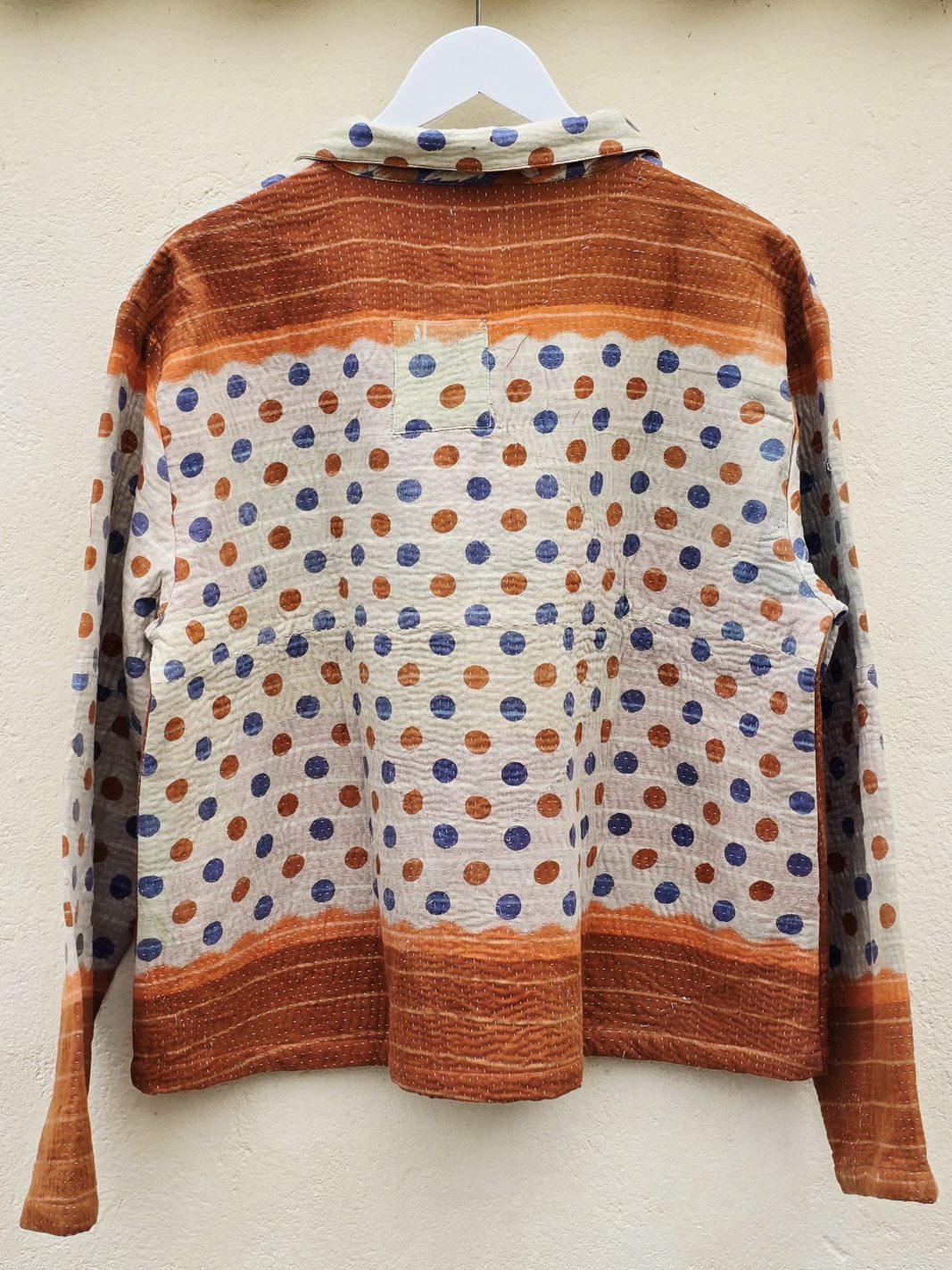 Prikket jakke med orange detaljer
